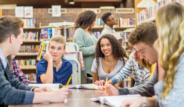 Adolescenti che leggono in una biblioteca scolastica