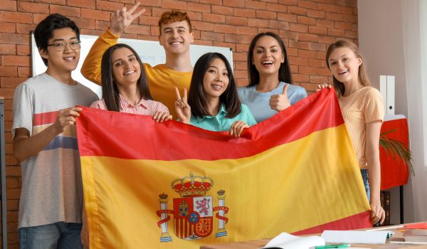 Gruppo di ragazzi adolescenti con in mano la bandiera della Spagna.