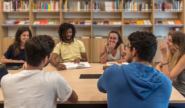 Un gruppo di ragazzi seduti intorno a un tavolo si confrontano
